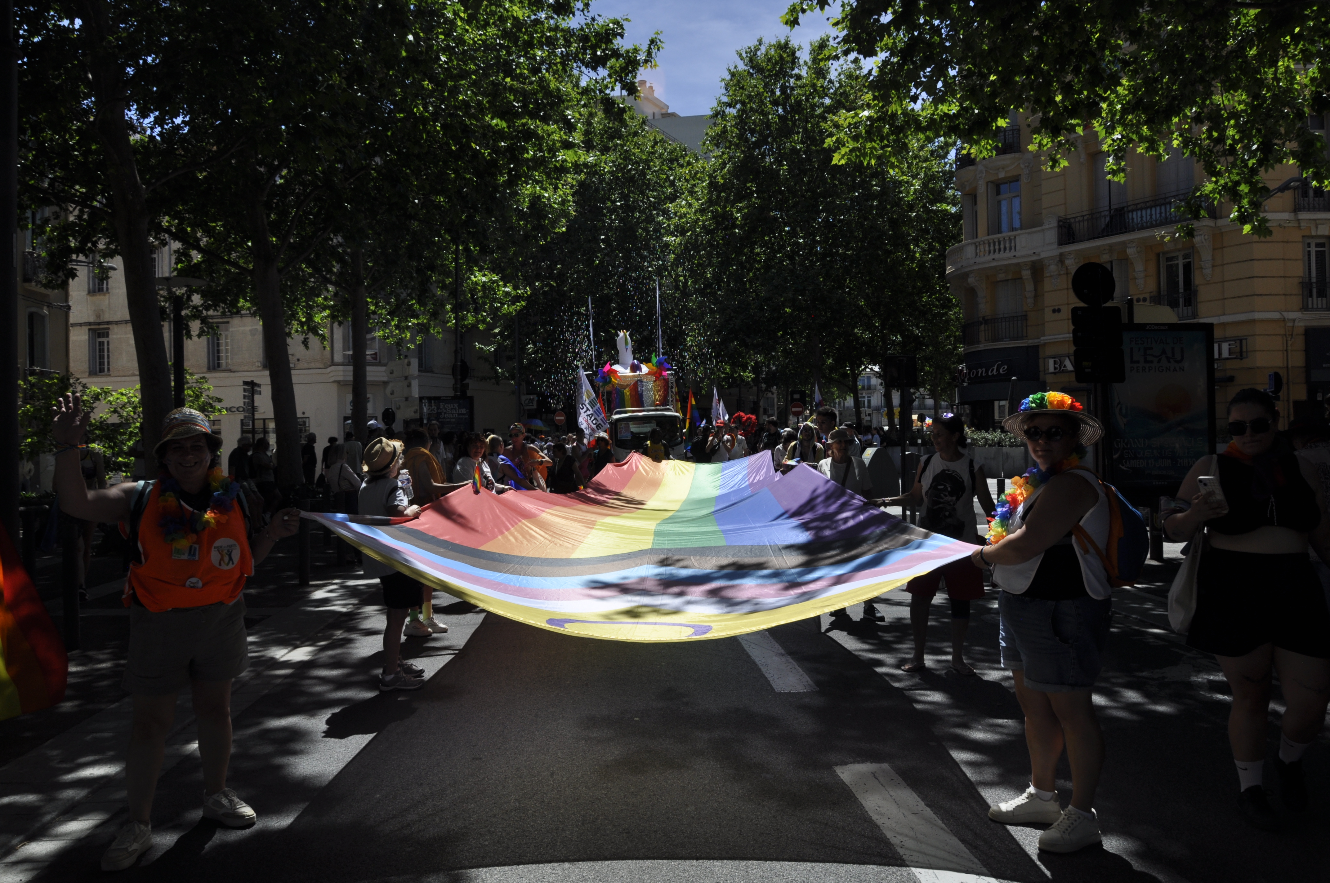 des personnes marchant enroulé dans le drapeau LGBT